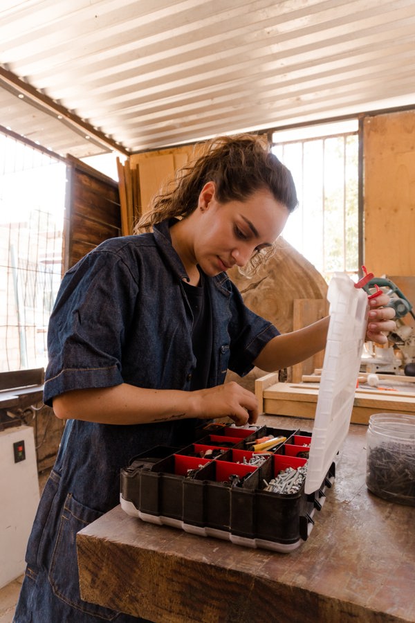 Woman opening a toolbox full of nails and screws