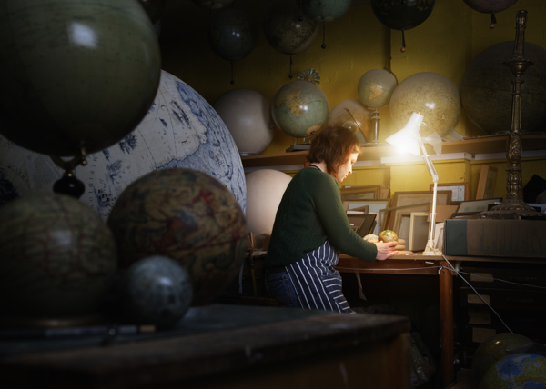Person is working in a workshop full of globes