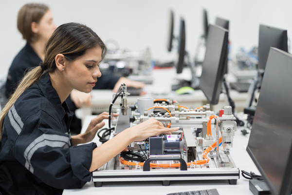 Two people working on computer cables and circuits