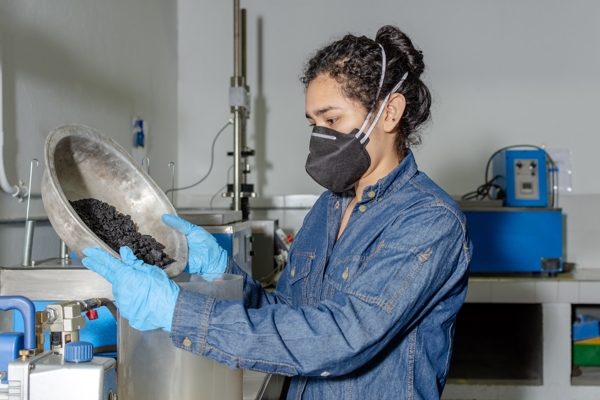 Person in a lab environment is using a sieve