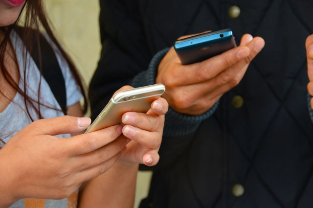Two people holding smart phones