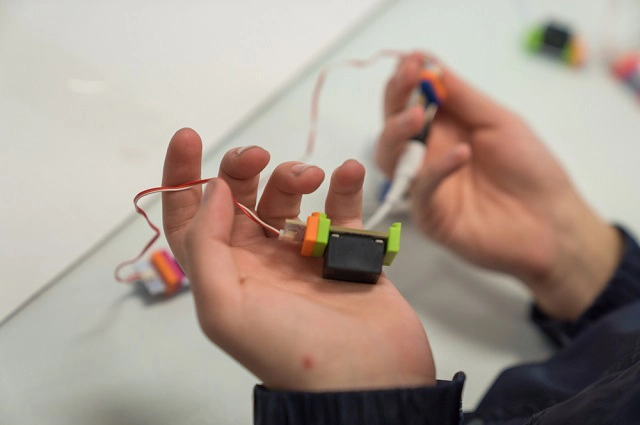 Childs hand holding wires