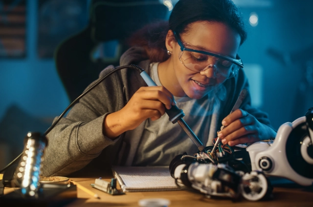 Person With Screwdrivers Working On A Robotic Part