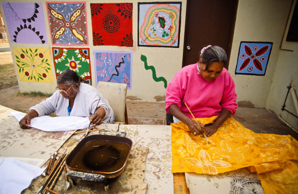 Two people are painting fabrics