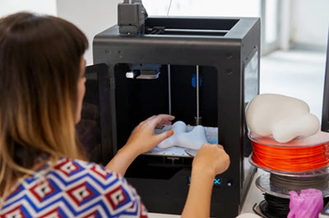 Woman with object in 3D printer