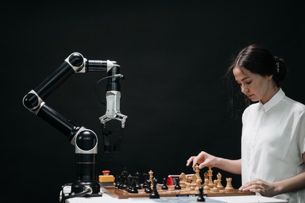 Woman playing chess against a robot