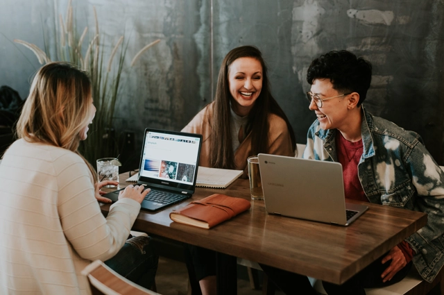 Three women working on laptops in a cafe