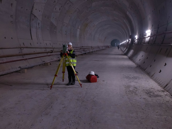 Person with a hard hat is looking through a geodetic station