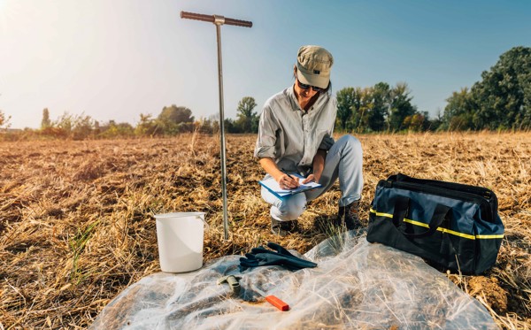Person in a field is taking notes 