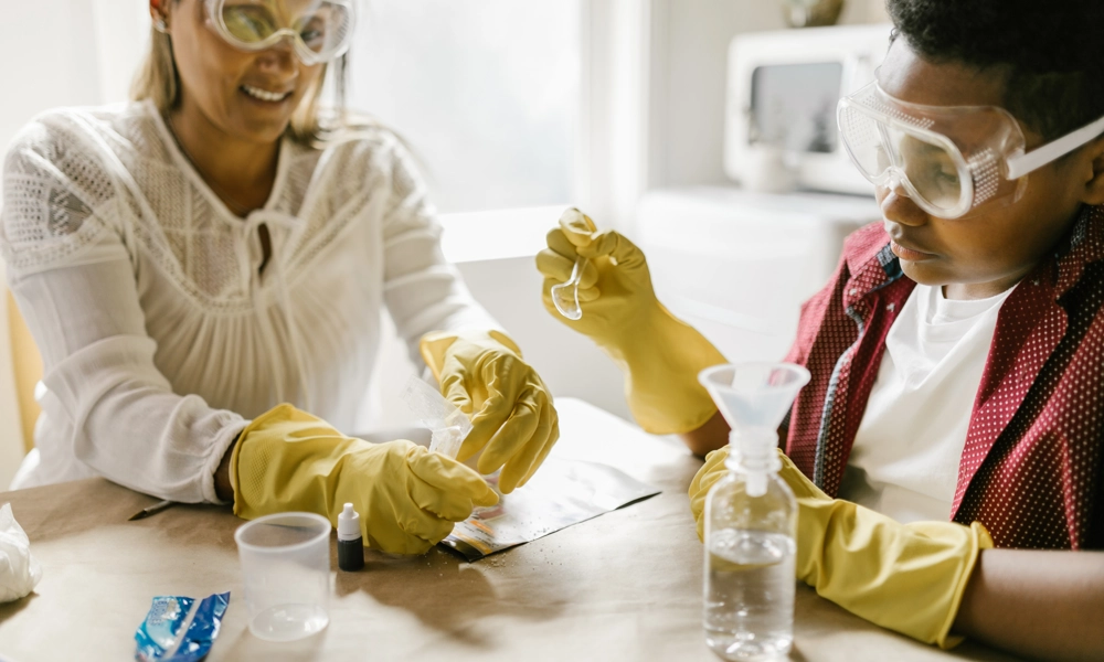 A woman and a boy wearing goggles and handling beakers