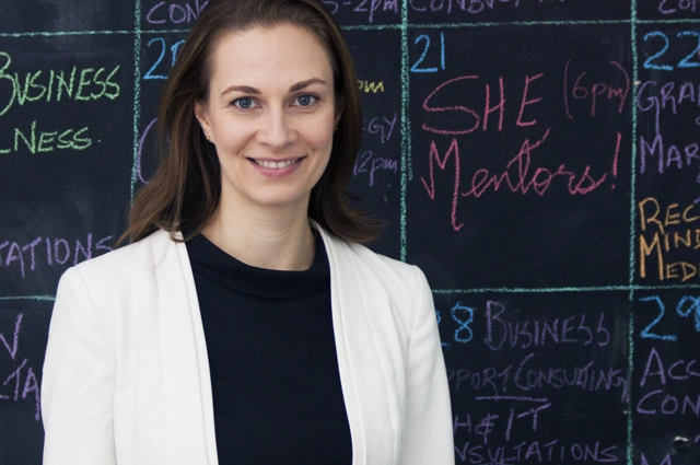 Headshot of Jillian Kenny standing in front of blackboard