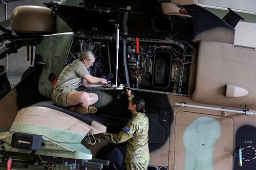 Two women mechanics working on helicopter